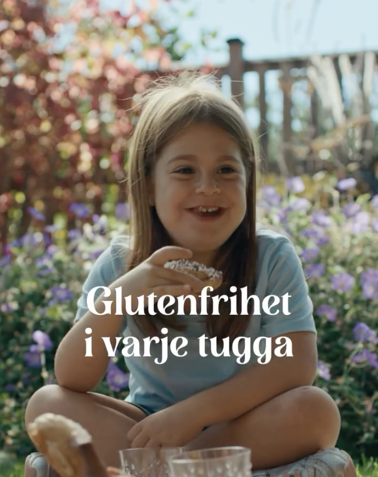 Glad flicka som äter glutenfri kanelbulle